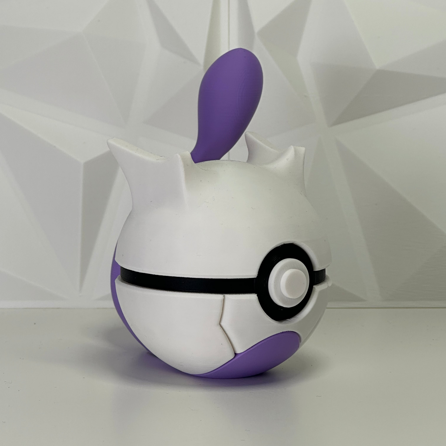 Primer plano de la Pokéball de Mewtwo, enfoque en el botón central y la elegancia de los colores legendarios