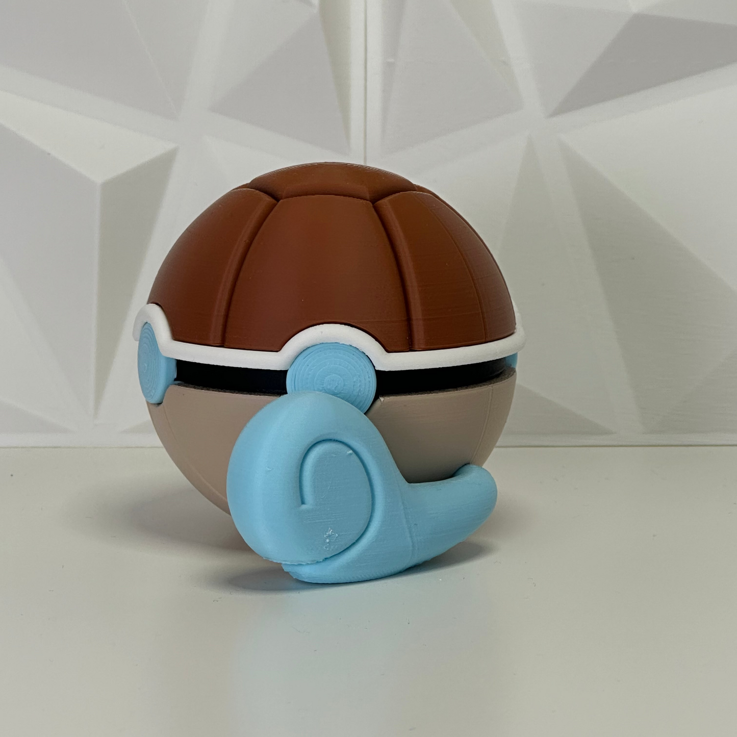 Vista trasera de la Pokéball de Squirtle, mostrando el patrón del caparazón y la conexión de la cola