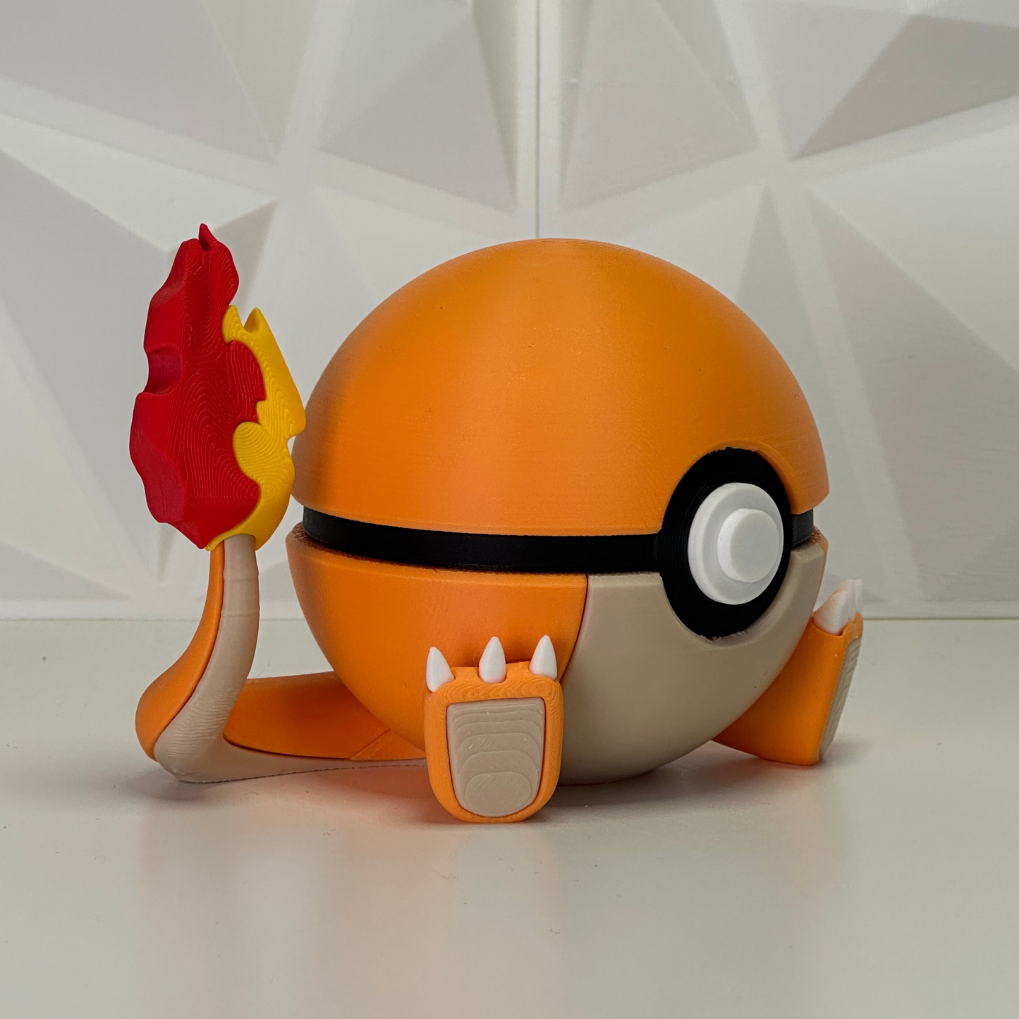 Primer plano de la Pokéball edición Charmander, detalle del botón central y las garras frontales