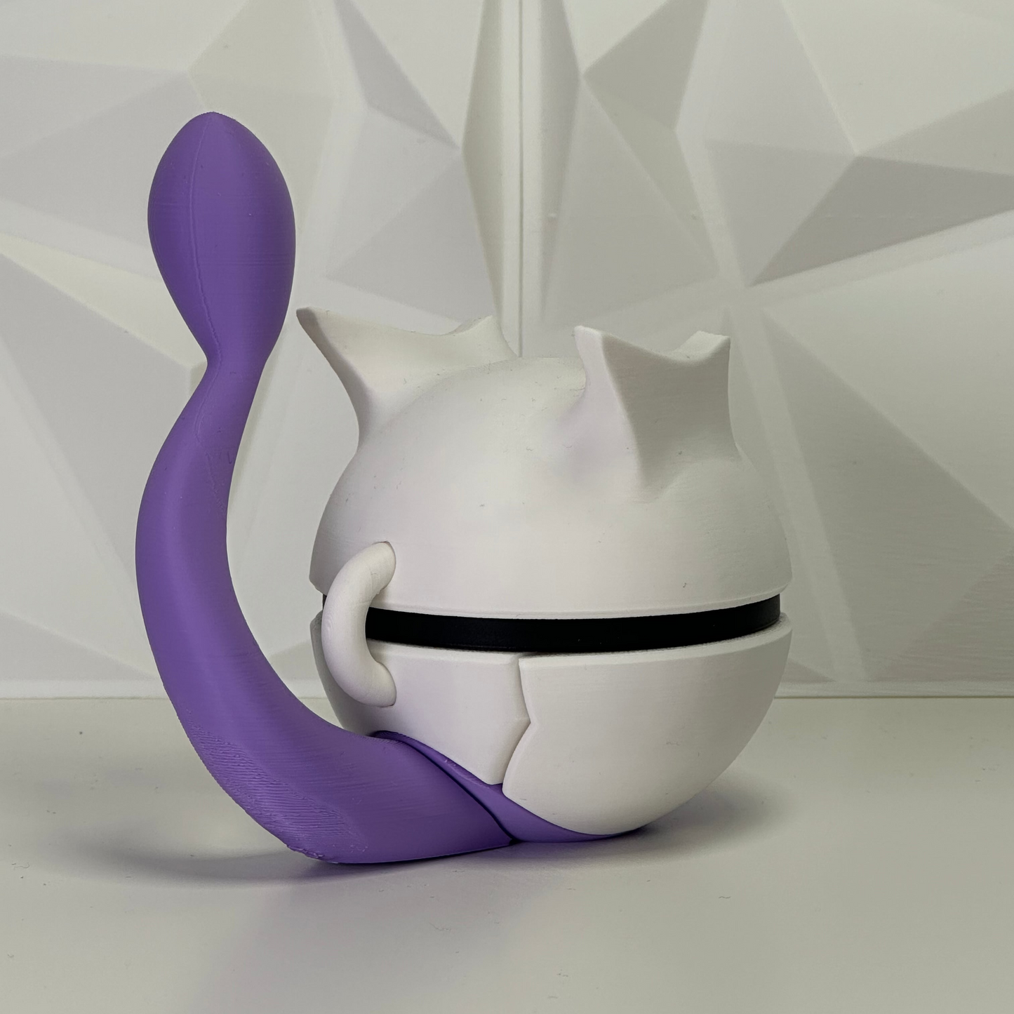 Vista lateral de la figura Mewtwo Pokéball resaltando la silueta aerodinámica y el acabado blanco