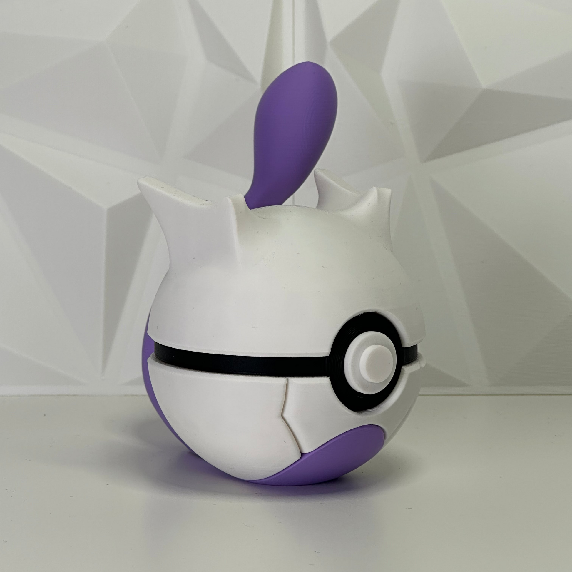 Primer plano de la Pokéball de Mewtwo, enfoque en el botón central y la elegancia de los colores legendarios